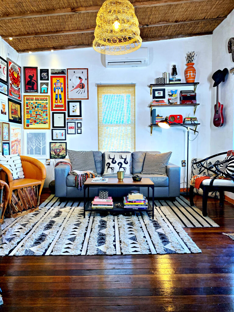 Eclectic Southwestern living room with corner gallery wall and shelf styling